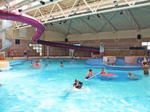 A busy swimming pool with children sitting on big floats