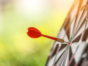 dart-board with a red dart and green background