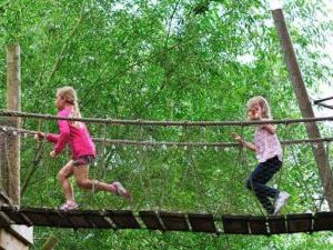 Kids running across the rope bridge at Groombridge Place