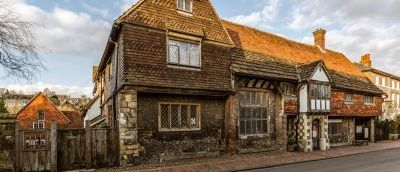 A picture taken of an old building which is on the side of a road.