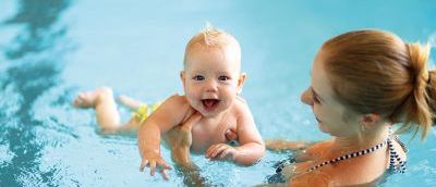 Mum holding baby in swimming pool